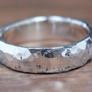May include: A silver hammered band ring with a textured finish.