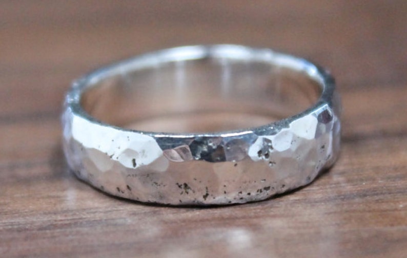 May include: A silver hammered band ring with a textured finish.