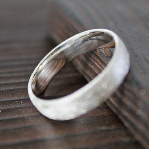 May include: A silver wedding band with a textured finish.