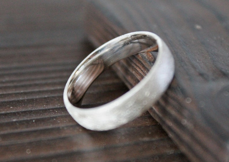 May include: A silver wedding band with a textured finish.
