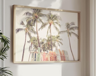 May include: A framed print featuring a tropical beach scene. Palm trees are in the background, with a colorful fence and surfboards in the foreground. The image has a soft, vintage aesthetic, with muted colors and a warm tone.