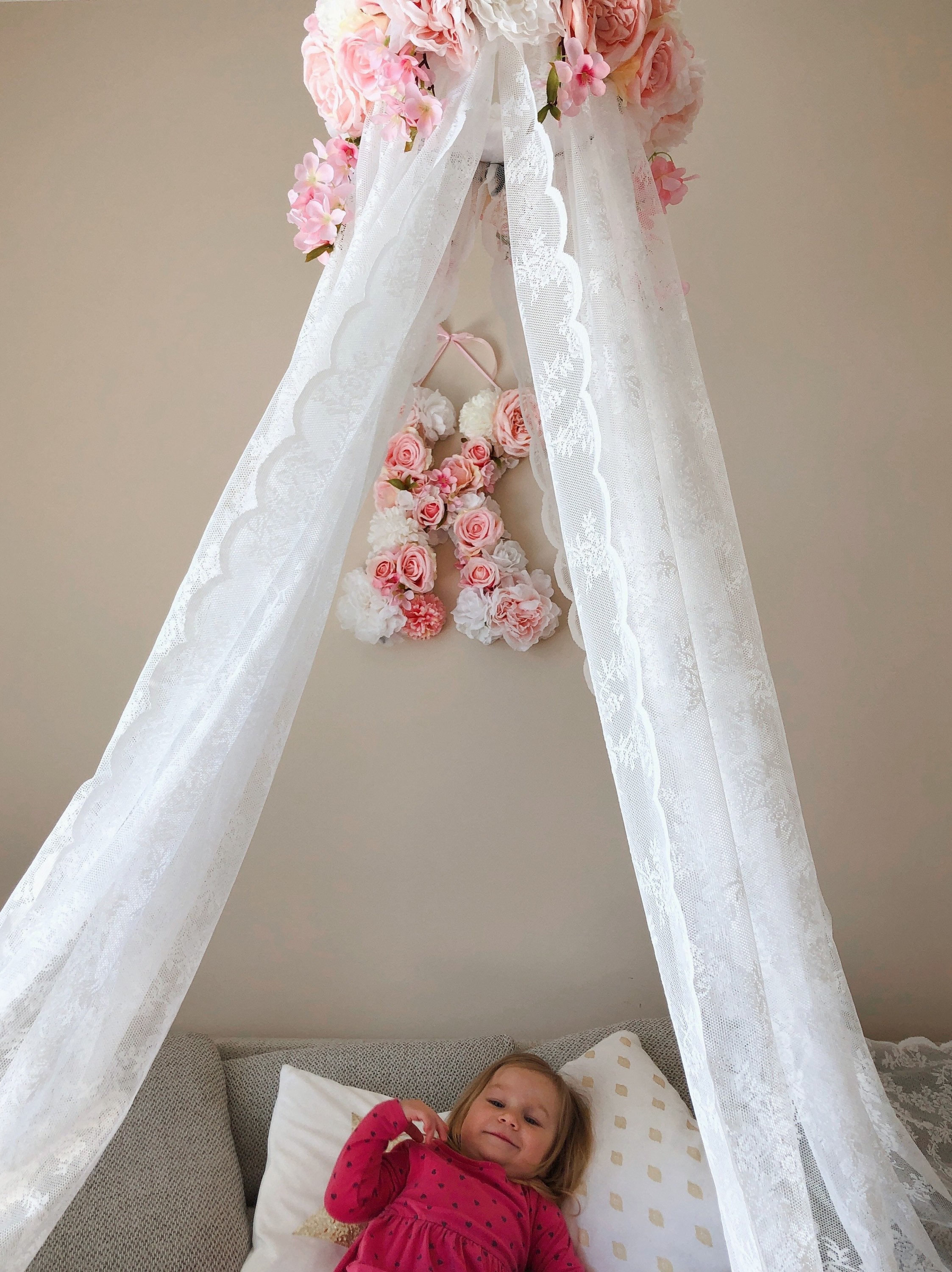 Dormitorio blanco diseñado para bebé niña. Por la pared cuna con dosel,  estantería y juguetes. En el oriente blanco sillón con almohadas Fotografía  de stock - Alamy