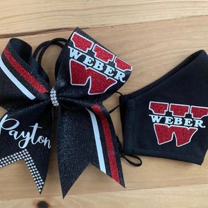 May include: A black glitter cheer bow with red and white accents, the name "Payton" in white script, and a matching face mask. Both items feature the word "WEBER" in red glitter.
