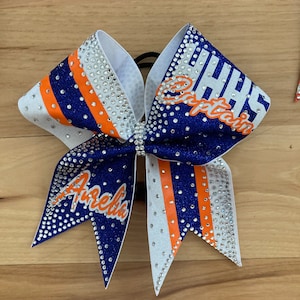 The Gaucho Custom glitter cheer bow covered in rhinestones. Bows made in your teams Colors. Price lIsted is per individual bow. Comp bow