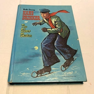 May include: A vintage Walt Disney book titled "Hans Brinker or The Silver Skates." The cover features an illustration of a person ice skating, wearing a green jacket, blue pants, and a red scarf. The background is a blue night sky with stars.