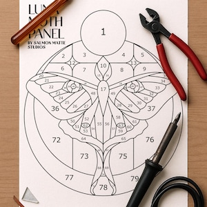 Puede incluir: Un detallado dibujo lineal de un diseño de panel de polilla numerado, junto con herramientas para vidrieras. Se ven un cortador de vidrio, unos alicates y un soldador, lo que sugiere un proyecto artesanal. Medidas en cm.