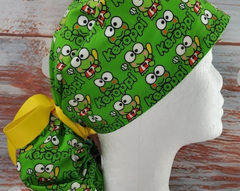 Peut inclure: Une charlotte chirurgicale vert vif ornée d'un motif répétitif du personnage de dessin animé Keroppi tenant une batte de baseball, avec le texte Keroppi imprimé partout. Le bonnet comprend une section arrière froncée fixée par un ruban jaune.
