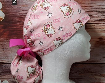 Peut inclure: Une charlotte chirurgicale rose clair ornée d'un motif répétitif de personnages Hello Kitty, de petites étoiles blanches et de nœuds roses. Le bonnet présente une section arrière froncée fixée par un ruban rose vif pour un ajustement serré.