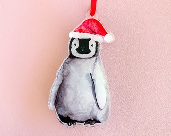 May include: A white penguin wearing a red Santa hat, a Christmas ornament.