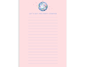 Op de afbeelding: Roze notitieblok met een blauwe discobal die erboven hangt. Het notitieblok heeft blauwe lijnen en de tekst "Let's get this party started" bovenaan.