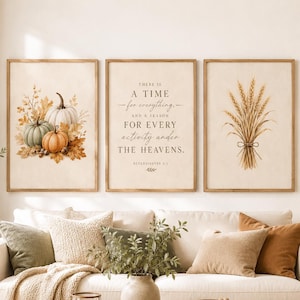 May include: A set of three framed wall art prints featuring a watercolor illustration of pumpkins and autumn leaves on the left, a central print with the text "THERE IS A TIME for everything, AND A SEASON FOR EVERY activity under THE HEAVENS.", and wheat.