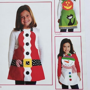 May include: A sewing pattern for children's aprons featuring holiday themes. The pattern includes three designs: Santa, Snowman, and Pumpkin. The pattern includes sizes 3-8.