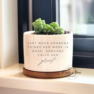 May include: White ceramic planter with a bamboo base. The planter has a quote that reads "Just when Grandma thinks her work is done, someone calls her great".
