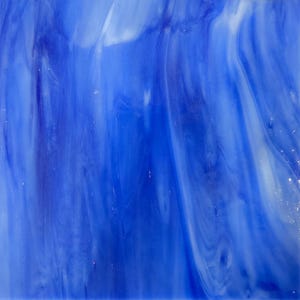 May include: Abstract close-up of a blue and white stained glass panel. The glass features swirling patterns of varying shades of blue, with streaks of white creating a dynamic, flowing design. The texture is smooth and reflective.