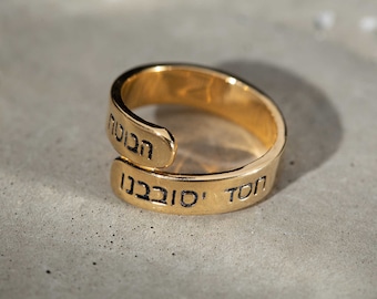 May include: A gold ring with the Hebrew words "TON" and "S'HABBA" engraved on it.