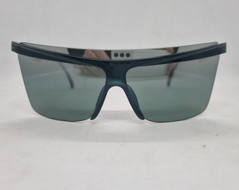May include: A pair of dark green sunglasses with a wraparound design. The lenses are tinted a dark grey color.