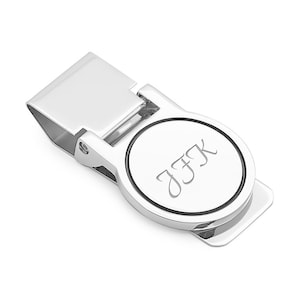 May include: Silver money clip with a round, engraved plate that says "JFK".