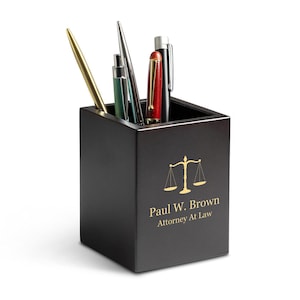 May include: Black wooden desk organiser with a gold scales of justice design and the text "Paul W. Brown Attorney At Law".