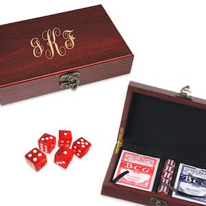 May include: A mahogany wood box with a brass latch, containing two decks of playing cards, five red dice, and a black felt lining. The box is engraved with the initials "SKF".