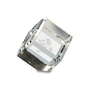 May include: A clear glass cube paperweight with the text "Step One Media Services" engraved on one side.