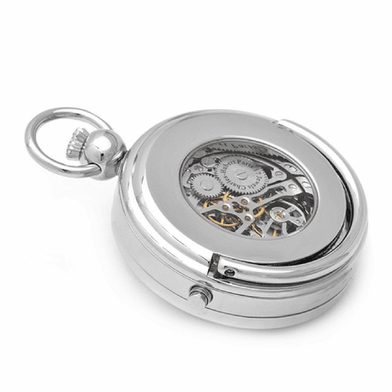 May include: A silver pocket watch with a clear back revealing the intricate mechanical workings. The watch has a hinged case and a small loop for attaching a chain.