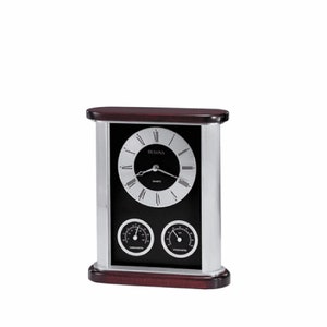 May include: A rectangular Bulova quartz clock with a dark wood top and base, and silver-colored sides. The clock face is black with silver Roman numerals and hands. Below the clock face are two circular gauges. The clock also has a thermometer and hygrometer.