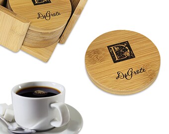 May include: Set of four round bamboo coasters with a personalized monogram and the name "De Grote" engraved in black. The coasters are stacked in a bamboo holder.