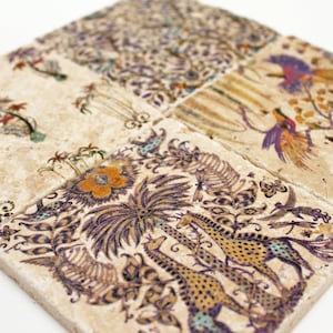 Könnte beinhalten: Set aus vier quadratischen Untersetzern mit beigem Hintergrund und aufwendigen Designs. Die Designs umfassen Palmen, Vögel und Giraffen in Lila, Orange und Grün. Jeder Untersetzer misst etwa 10 cm im Quadrat.