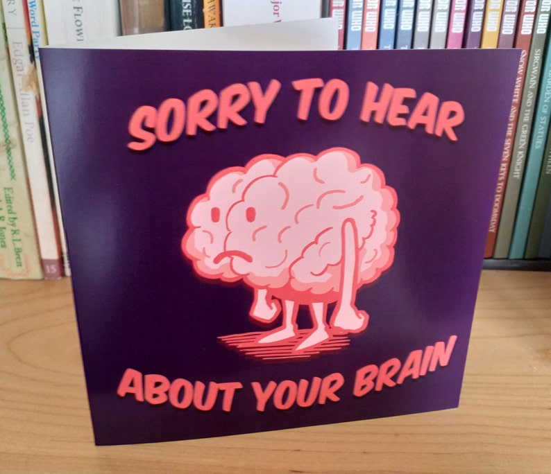 May include: A purple card with a pink cartoon brain with a sad expression. The card says "Sorry to hear about your brain."