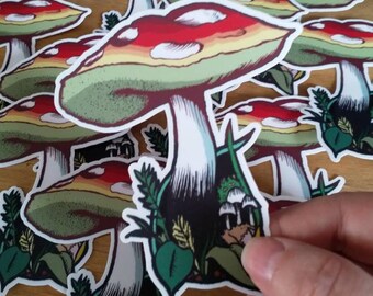 May include: A set of colorful mushroom stickers with red, white, and green accents. The mushrooms are illustrated with a detailed design and are surrounded by green foliage.