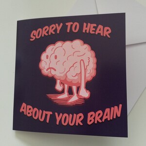 May include: A greeting card with a pink cartoon brain with arms and legs. The brain is sad and the card says "Sorry to hear about your brain".