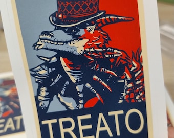 May include: A playing card featuring a stylized illustration of a creature wearing a top hat. The design uses red, blue, and white colors. The word "TREATO" is printed in large white letters at the bottom of the card.
