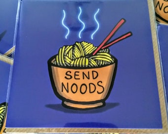 May include: A purple card with a cartoon illustration of a bowl of noodles with chopsticks. The bowl is orange and the noodles are yellow. The text "SEND NOODS" is written on the bowl.