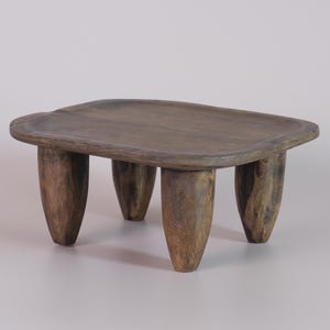 May include: A small, wooden table with a rectangular top and four rounded legs. The table is made of dark brown wood and has a rustic, natural look.