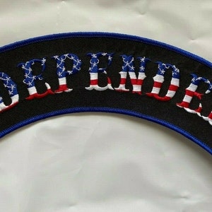 May include: A black and blue embroidered patch with the word "INDEPENDENT" in white lettering. The letters are outlined in red, white, and blue, resembling the American flag.