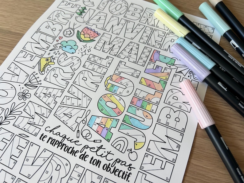Pode incluir: Uma folha de atividade de colorir por n&uacute;meros com os meses do ano em letras grandes e estilizadas. Cada letra &eacute; dividida em se&ccedil;&otilde;es numeradas, prontas para serem coloridas com marcadores ou l&aacute;pis de cor. O texto na parte inferior diz "chaque petit pas te rapproche de ton objectif."