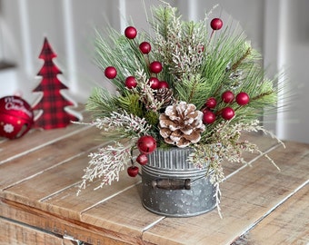 Small Farmhouse winter Christmas floral arrangement in a galvanize small pail Container with snow pock a dots, evergreens berries pinecones