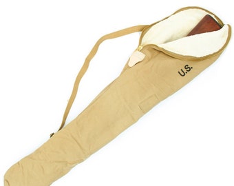 May include: Tan canvas rifle case with a cream-colored, fuzzy interior. The case has a zipper closure, a shoulder strap, and the letters "U.S." printed on the side. A wooden rifle is partially visible inside.