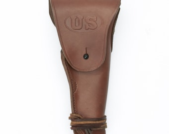 May include: A brown leather holster with a flap and a strap. The flap has a US stamp embossed on it.