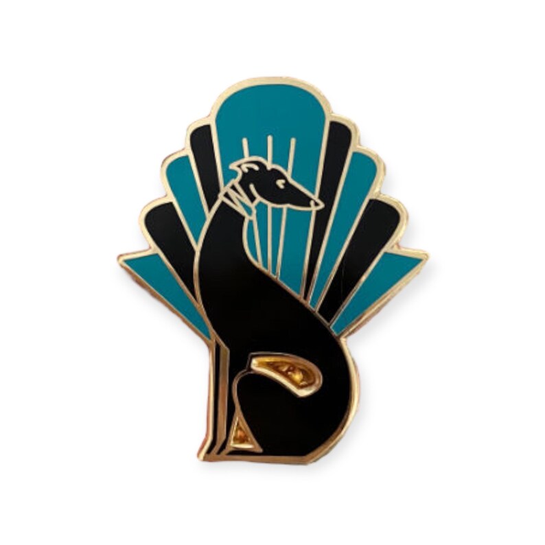 Pode incluir: Um broche de esmalte dourado com uma silhueta preta de um galgo sentado em frente a um leque art d&eacute;co azul-turquesa e preto.