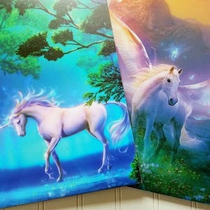May include: Two fantasy-themed binders featuring unicorns and pegasus. One binder shows a white unicorn with a long horn in a blue forest setting. The other binder shows a white pegasus with large wings in a colorful landscape.