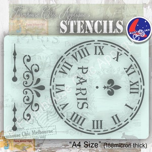 Op de afbeelding: Een grijze stencil van een wijzerplaat met Romeinse cijfers en het woord "PARIS" in het midden. De stencil is op een lichtblauwe achtergrond en is gelabeld "A4 Size" (188 micron dik).