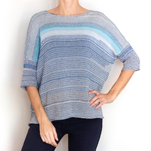 May include: A blue and white striped knit sweater with a loose fit and 3/4 sleeves.
