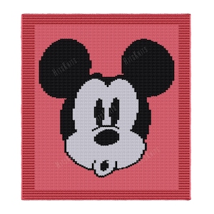 Può includere: Una coperta quadrata lavorata a maglia con la faccia di Topolino in bianco e nero su sfondo rosa. La coperta ha un bordo rosso e il testo "Hits Knits" negli angoli.