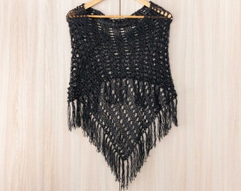 May include: Black crochet poncho with fringe trim. The poncho is made of a lightweight, open-weave fabric.