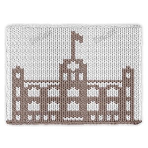 May include: A rectangular, knitted item featuring a detailed brown and white design of a building with a flag. The background is a light beige color. The text "Hitsknits" is visible on the top edge.