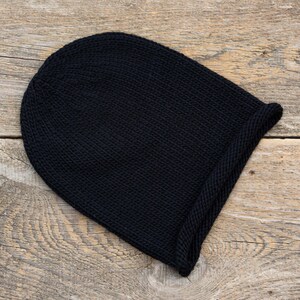 May include: A black knitted beanie with a folded brim.