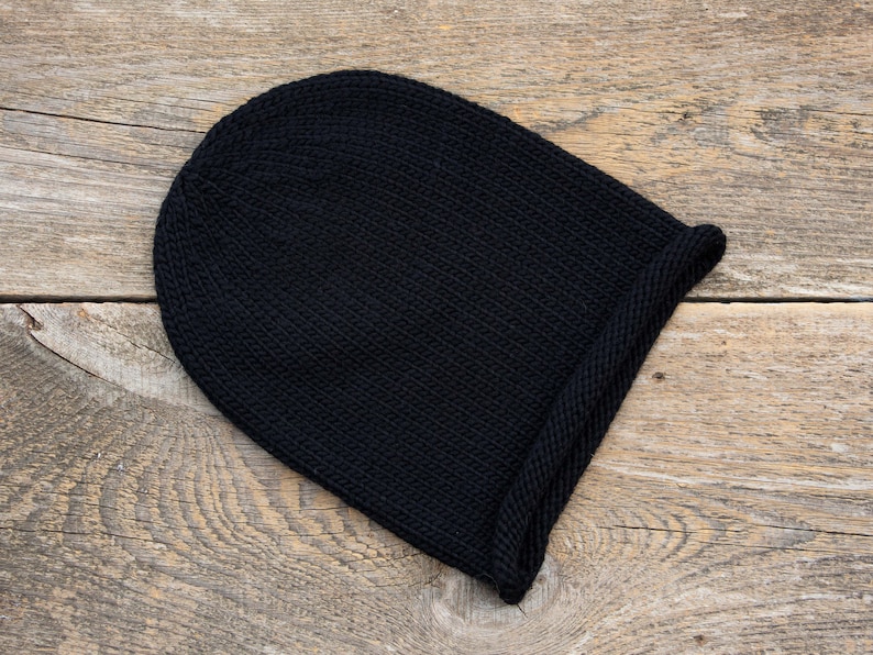May include: A black knitted beanie with a folded brim.