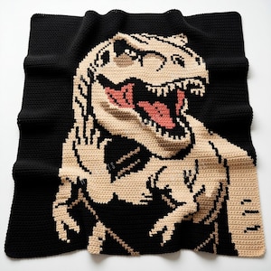 Könnte beinhalten: Eine gehäkelte Decke in Schwarz und Beige mit einem Tyrannosaurus Rex-Design. Das Maul des Dinosauriers ist geöffnet und zeigt ein rosa Inneres. Die Decke ist aus weichem Garn gefertigt und quadratisch. Ideal für ein Kinderzimmer oder als dekorativer Überwurf, ca. 150 cm x 150 cm.