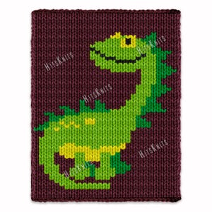 Op de afbeelding: Een gebreide bordeauxrode rechthoek met een groen en geel dinosaurusontwerp. De dinosaurus heeft een lachend gezicht en is omgeven door de tekst "Hits Knits". Het ontwerp is gemaakt van verschillende tinten groen en geel.